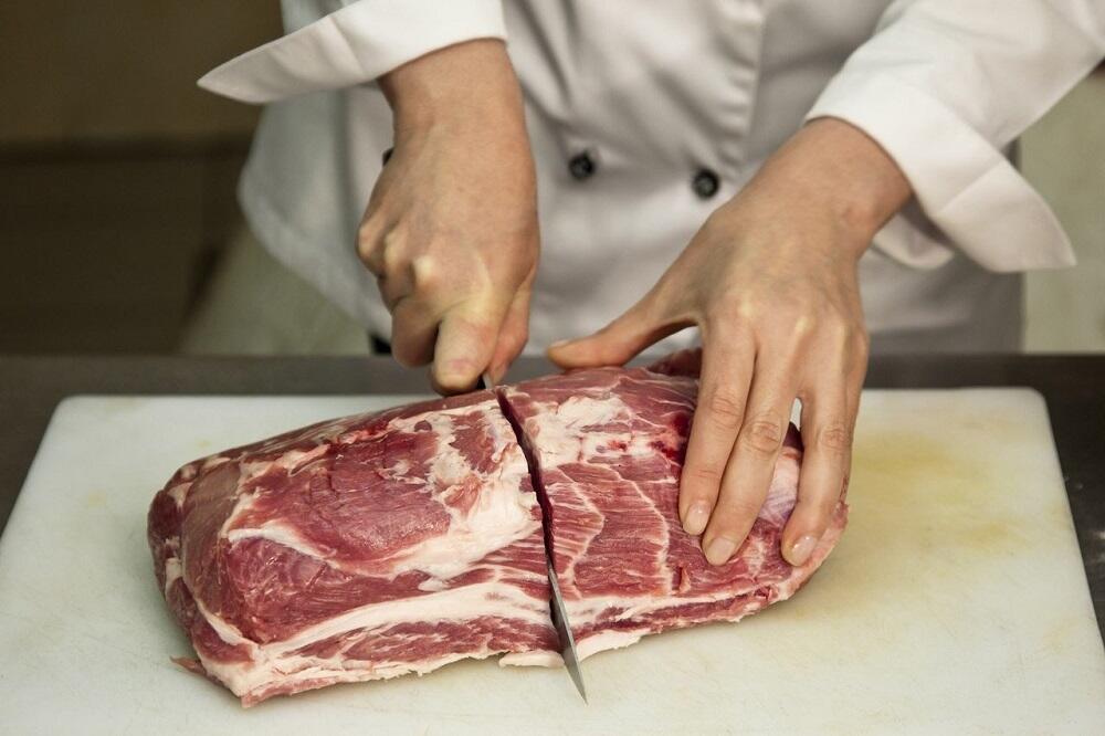Человек разрезает мясо