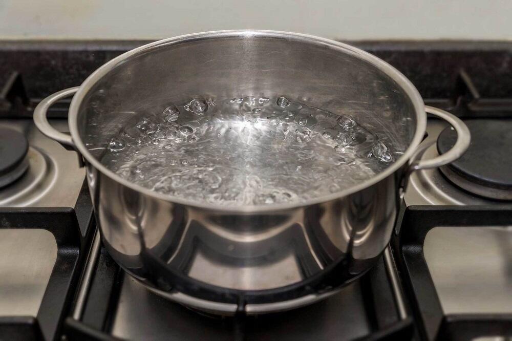 Кипящая вода в кастрюле Кастрюля с водой на плите