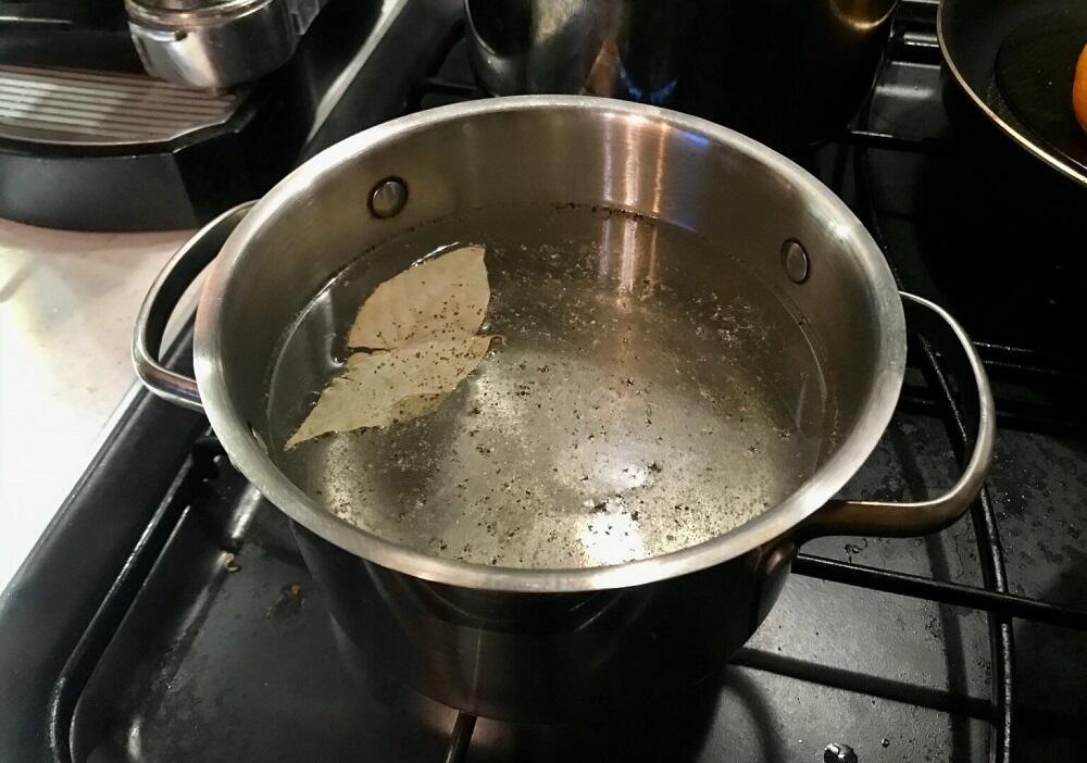 Добавление лаврового листа и специй в воду Кипящая вода с лаврушкой и перцем